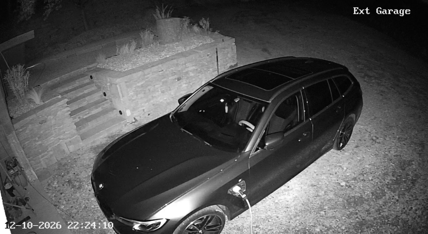 Vue nocturne d’une caméra de vidéosurveillance extérieure montrant une allée et un véhicule